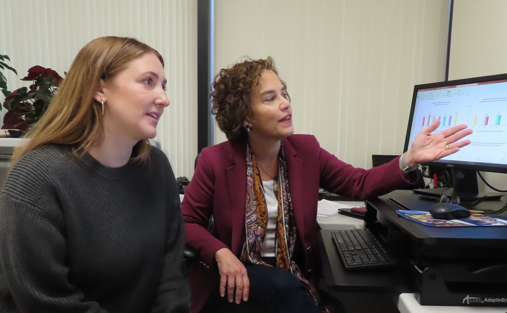 IPRO employees examine data on a computer monitor