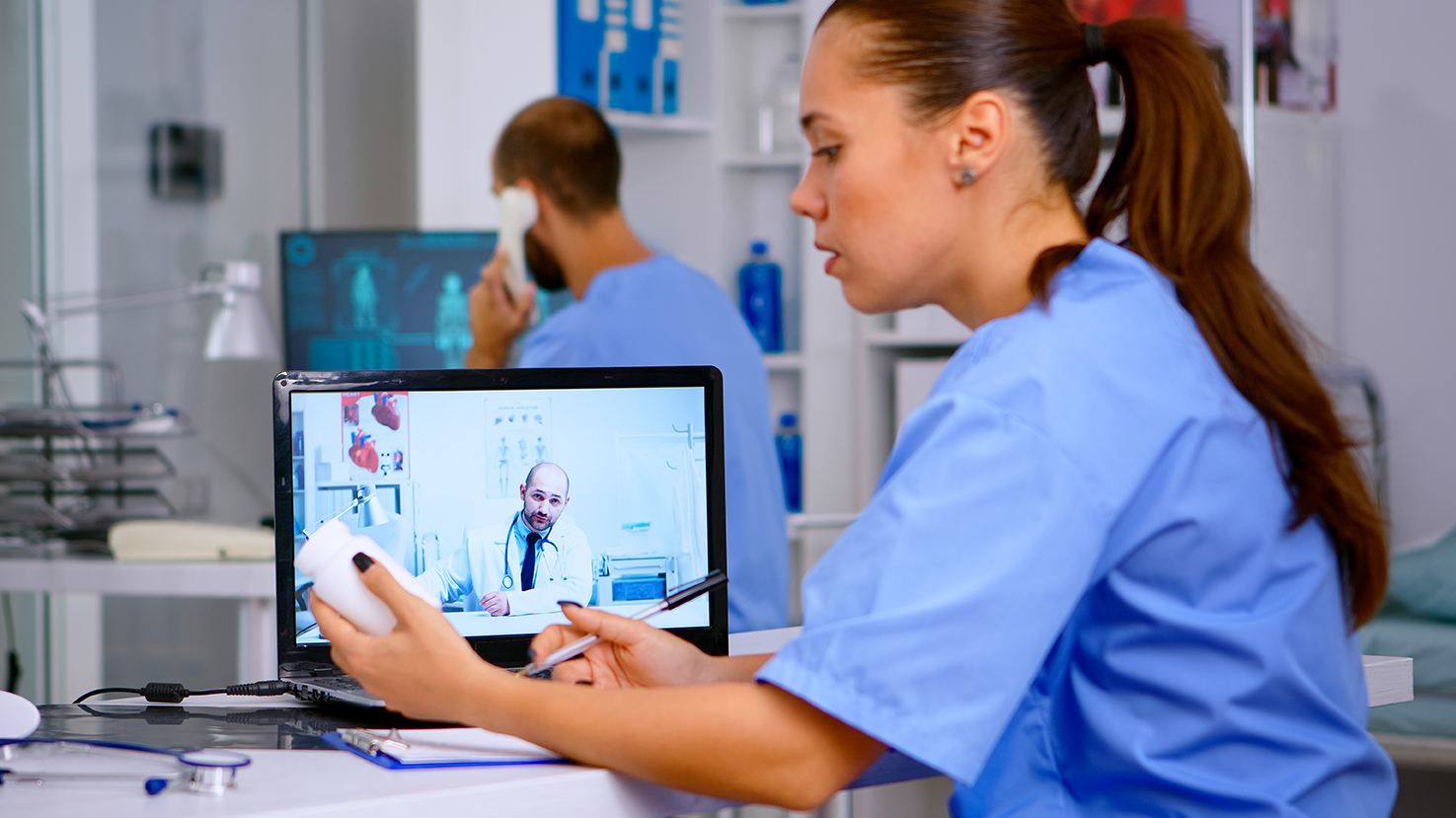 Resident physician talking to doctor on video call during virtual meeting