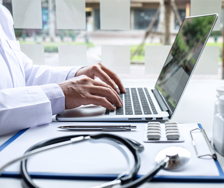 Hands on a keyboard with a stethoscope in the foreground