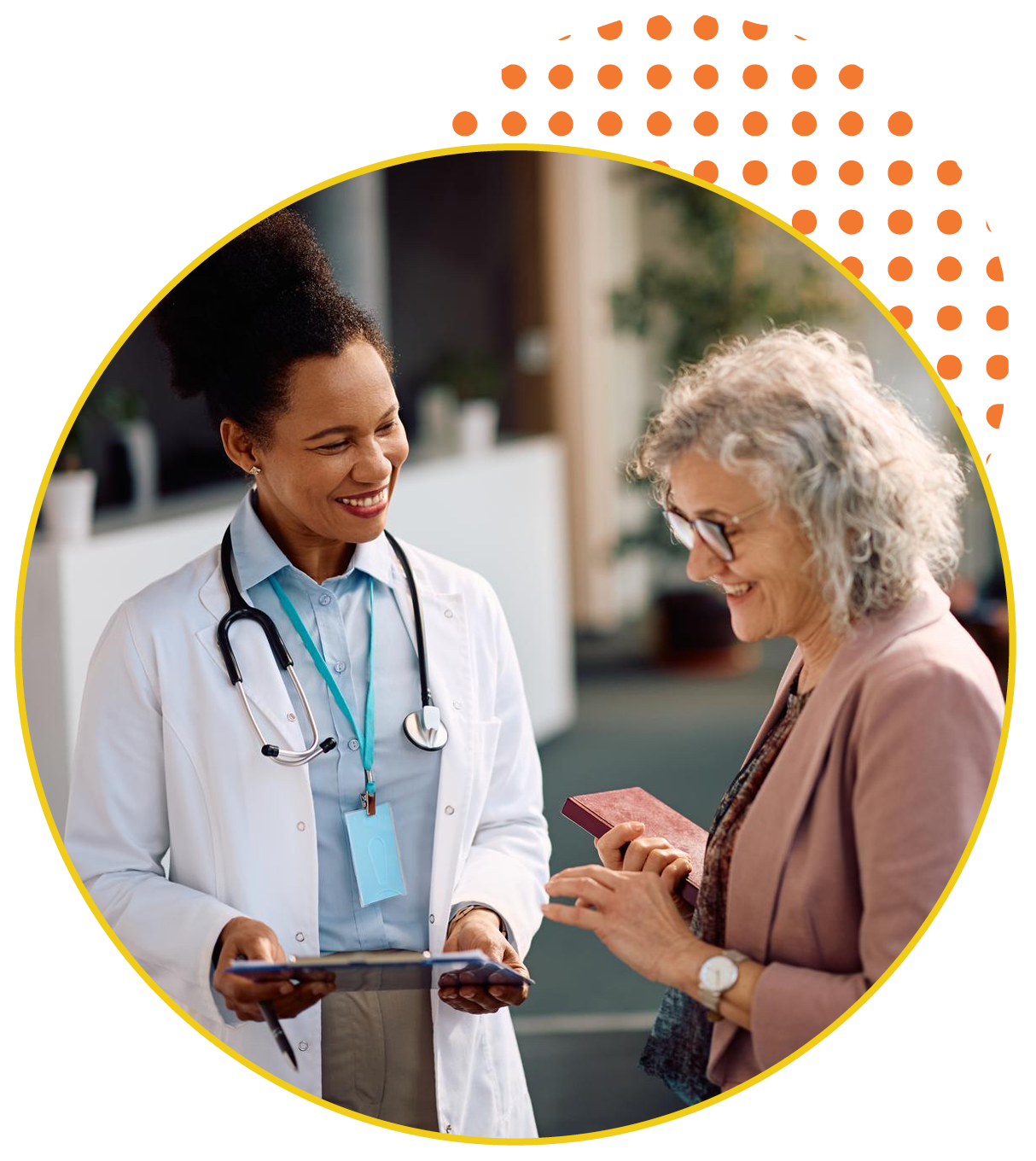Young female doctor speaks with older white-haired female patient.